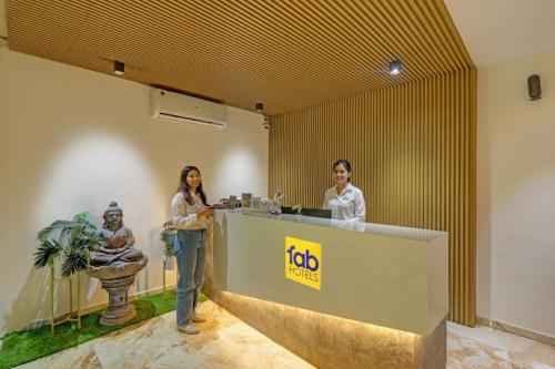 two women standing at a reception desk in a room at FabHotel Blue Moon in Hanamkonda