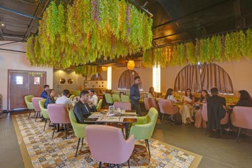 a group of people sitting at tables in a restaurant at FabHotel Blue Moon in Hanamkonda
