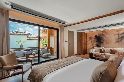 a bedroom with a large bed and a large window at Hotel NANDANA in Diannan
