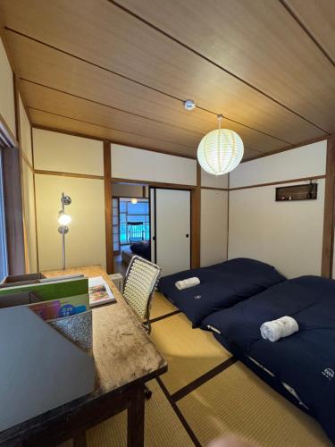 a room with two beds and a desk and a table at 嬉々の屋KIKI Chalet in Hakuba
