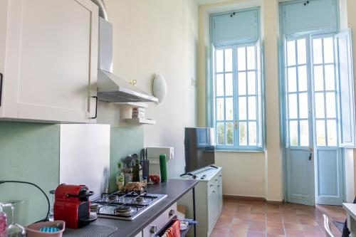 a kitchen with a stove and some windows in it at Principi di Piemonte Apartments in Tirrenia