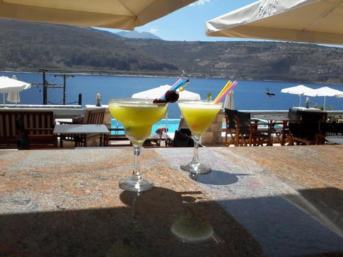 two cocktails on a table with a view of the water at Εn Plo Luxury Suites in Karavostasion