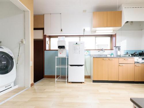a kitchen with a refrigerator and a washing machine at わのおうち善 in Nitanzawa