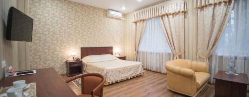 1 dormitorio con 1 cama, 1 silla y 1 mesa en Record Hotel, en Zelenograd