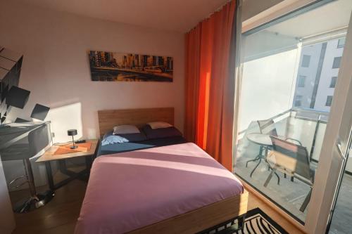 a bedroom with a bed and a desk and a window at Rezidencia Albelli in Košice