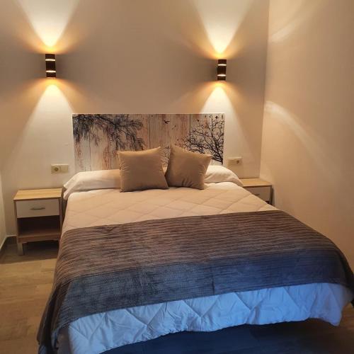 a bedroom with a large bed with two pillows at B&B Ágora in Sayalonga