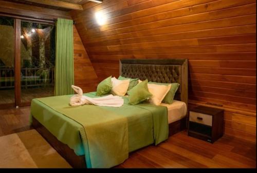 a bedroom with a bed with a green comforter at Monsoon Cabana Ella in Ella
