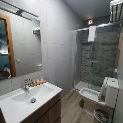a bathroom with a sink and a toilet and a mirror at B&B Ágora in Sayalonga
