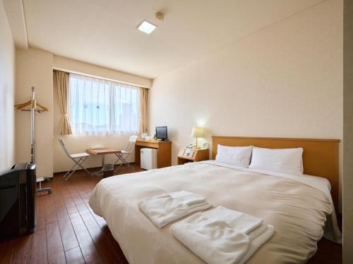 a hotel room with a large bed and a desk at Hotel Sincerity kani in Kani