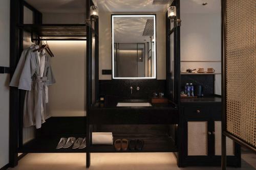 a black bathroom with a sink and a mirror at CHUN LIN BOUTIQUE HOTEL in Dali