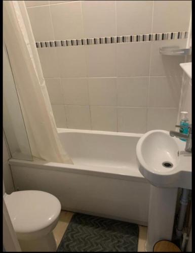 a bathroom with a toilet and a tub and a sink at Self contained Studio apartments in Eastbourne