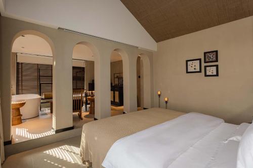 a bedroom with a bed and a bathroom with a tub at CHUN LIN BOUTIQUE HOTEL in Dali