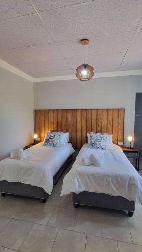 a bedroom with two beds and a chandelier at Maggie's Farm Stay in Khanzi