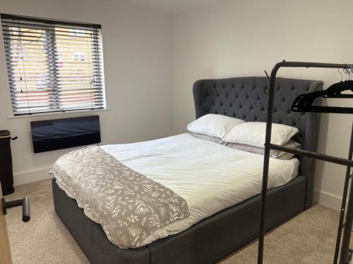 a bedroom with a bed with a gray head board at Olivers retreat in Braintree
