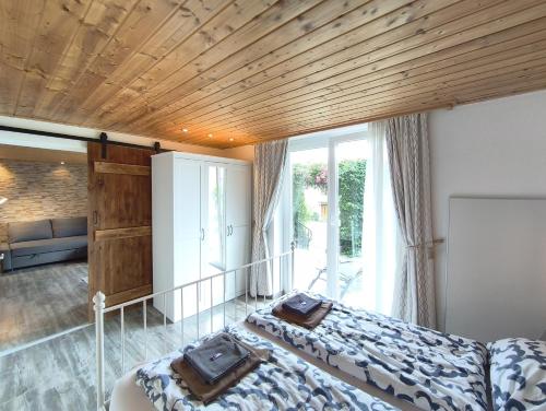 a bedroom with a bed with a wooden ceiling at Landhaus Danita in Bodensdorf