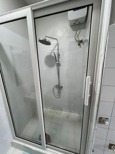 a shower with a glass door in a bathroom at Spacious one bedroom Bangalow -8E3 in Kampala