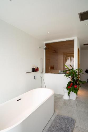 a white bath tub in a bathroom with a plant at Amatera in Kami Amakusa