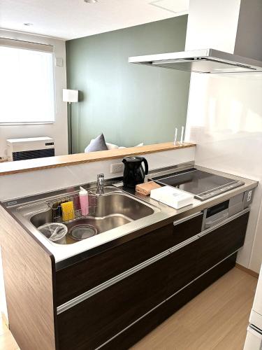 a kitchen with a sink and a counter top at ニセコ泉居アパートメント in Kutchan