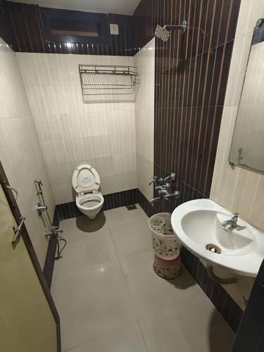 a bathroom with a toilet and a sink at Hotel Vishal - Near Surat Railway Station in Surat