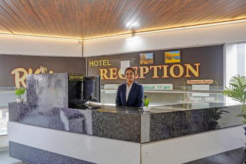 a woman standing at a counter in a hotel reception at FabHotel RK Inn in Pune