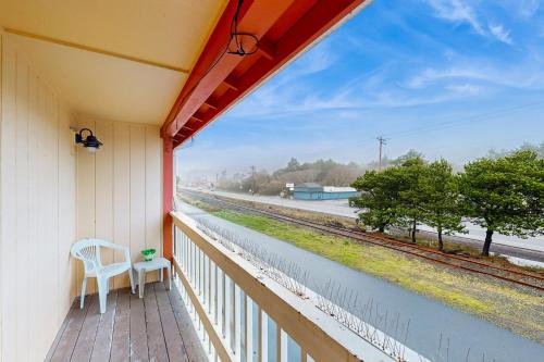 a porch with a chair and a view of a train track at Sea Treasures Inn #210 in Rockaway Beach