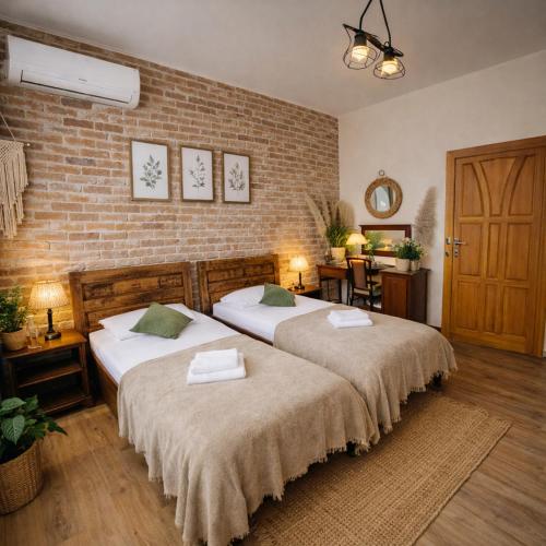 a bedroom with two beds and a brick wall at Hotel Aslan in Tarnowskie Góry