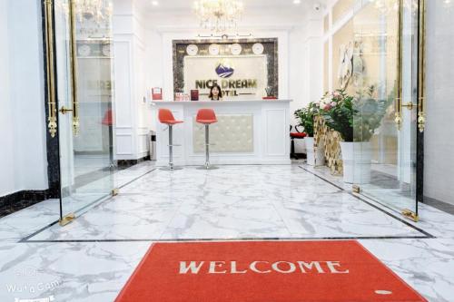 a welcome sign on the floor of a lobby with a welcome mat at Nice Dream Hotel in Yen