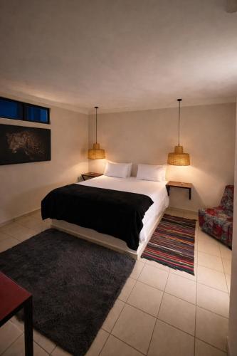 a bedroom with a large bed and two lamps at Bougainvilla Kolwezi Guesthouse in Kolwezi