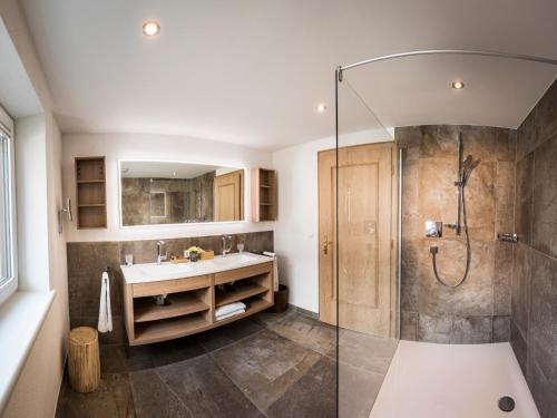 a bathroom with a shower and a sink at Hotel Hirlanda in Zürs am Arlberg