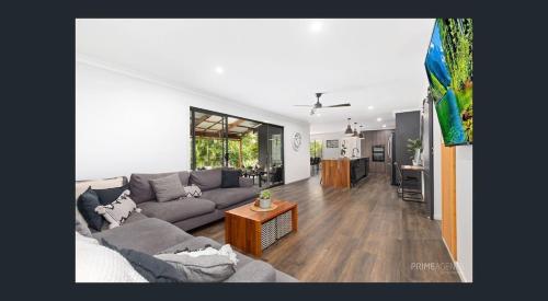 a living room with a couch and a table at Between Trees and Tide in Torquay