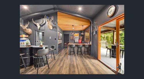 a kitchen with a bar and stools in a house at Between Trees and Tide in Torquay
