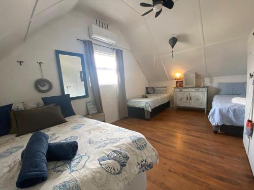 a bedroom with two beds and a ceiling fan at Joan's Sea Cottage in Pringle Bay