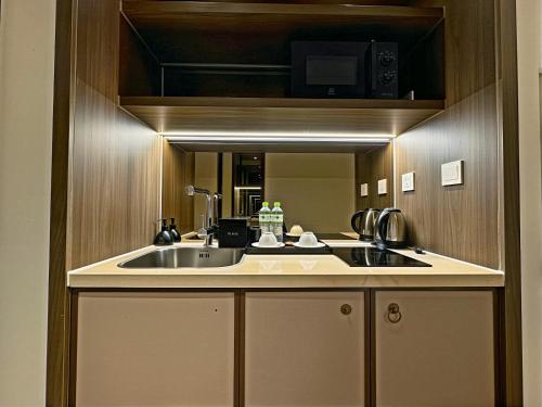 a kitchen with a sink and a microwave at Mandala Sands Mũi Né in Phan Thiet
