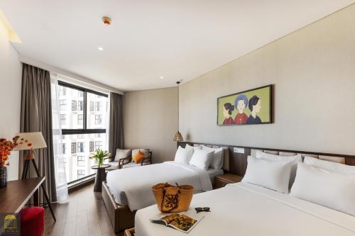 a hotel room with two beds and a window at Mandala Sands Mũi Né in Phan Thiet