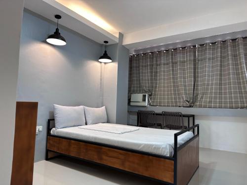 a bedroom with a bed with two lights on it at Capitol Tourist Inn 2026 in Cebu City