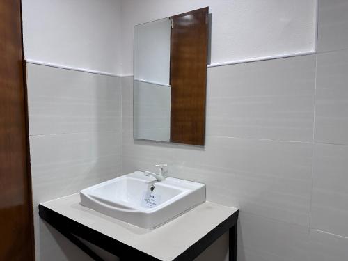 a white bathroom with a sink and a mirror at Capitol Tourist Inn 2026 in Cebu City