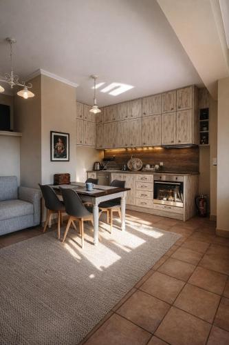 a living room with a table and chairs and a kitchen at Pera Vrisi in Zátouna