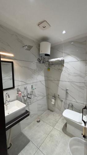 a bathroom with a sink and a toilet at Hotel Buransh in Haldwāni
