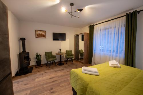 a bedroom with a green bed and a fireplace at DIM Studio in Braşov