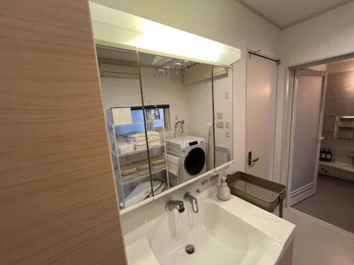 a bathroom with a sink and a mirror and a microwave at Stay923 in Asahikawa