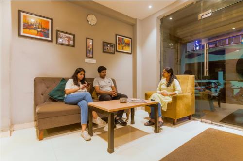 a group of people sitting in a living room at FabHotel MB International in Kolkata