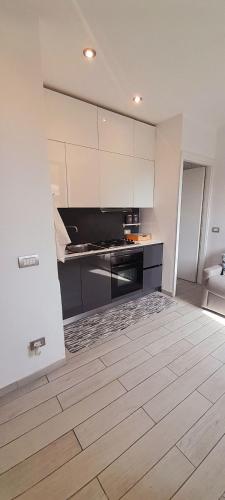 a kitchen with white cabinets and a wooden floor at Appartamento La Corte in Inveruno