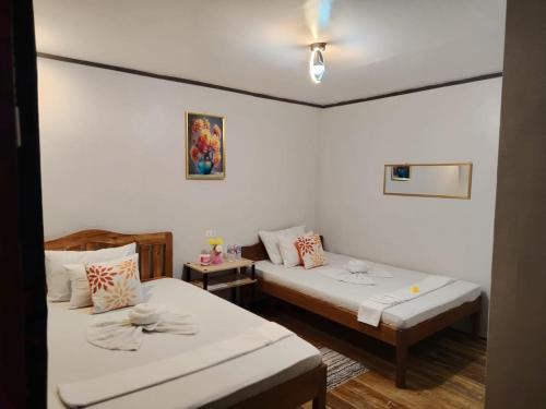 a room with two beds and a couch in it at EL3 Z'sPLACE HOSTEL in San Vicente