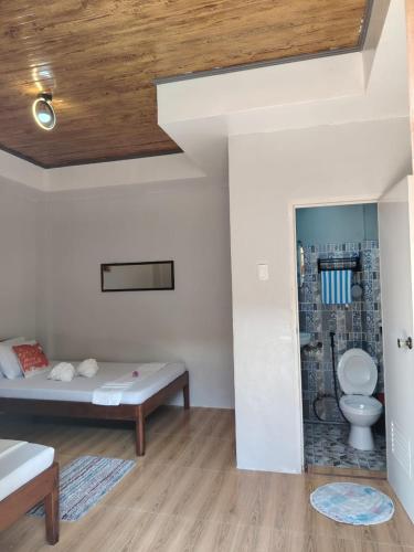 a bedroom with a bed and a toilet in a room at EL3 Z'sPLACE HOSTEL in San Vicente