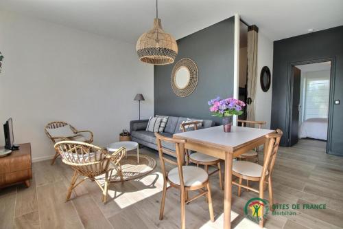 ein Wohnzimmer mit Tisch, Stühlen und Sofa in der Unterkunft Mor glaz in Locmariaquer