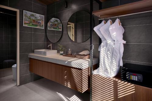 a bathroom with a sink and a mirror at Romhaey Kirirom Resort by EHM in Phumĭ Péam Lvéa