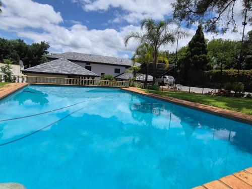 a large pool with blue water in front of a house at Namloom Guesthouse in Pretoria
