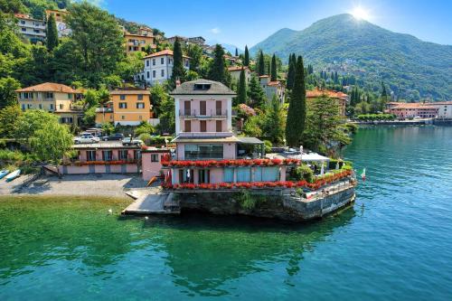 a house on a dock in a body of water at Hotel Meridiana in Bellano
