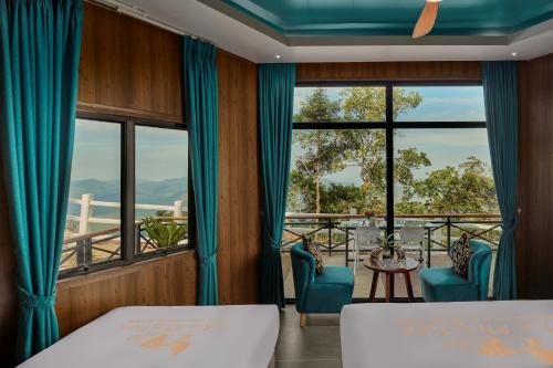 a room with two beds and a balcony with a view at Romhaey Kirirom Resort by EHM in Phumĭ Péam Lvéa
