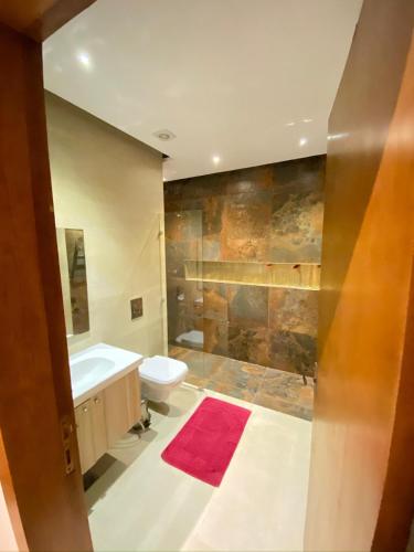 a bathroom with a toilet and a tub and a sink at Cordoba Suites in Hurghada